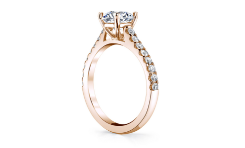 A rose gold cathedral engagement ring from Kirk Bridal with diamond side stones, available at Kirk Jewelers.