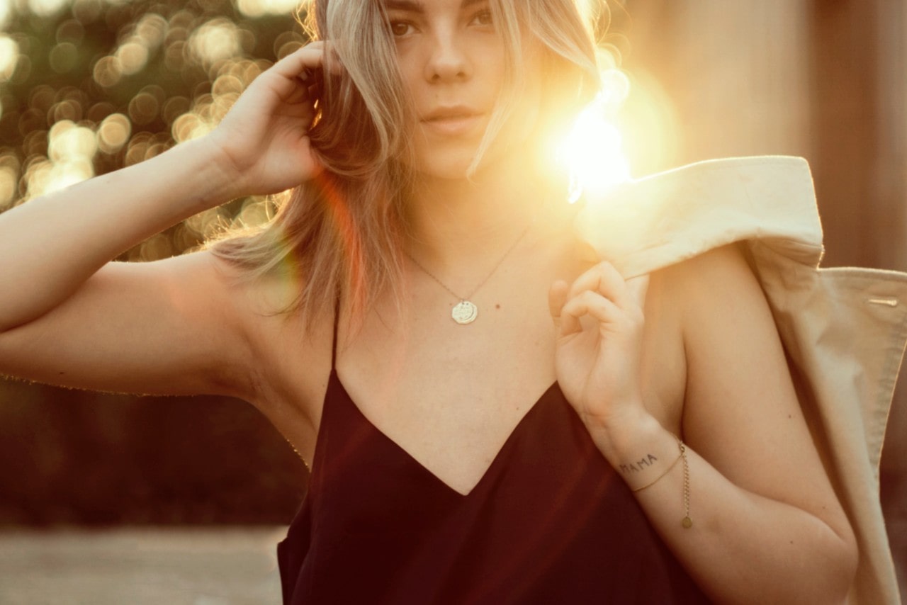 Woman wearing a gold necklace during golden hour before sunset