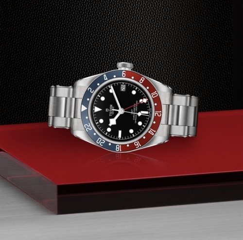 TUDOR Black Bay GMT 41mm stainless steel watch on red surface, available at Kirk Jewelers.