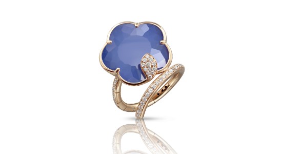 a rose gold fashion ring featuring a blue, flower-shaped center stone and a winding band