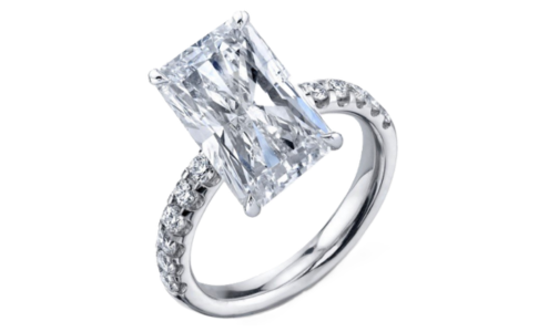 A glistening platinum side stone engagement ring with an emerald center stone, available at Kirk Jewelers.