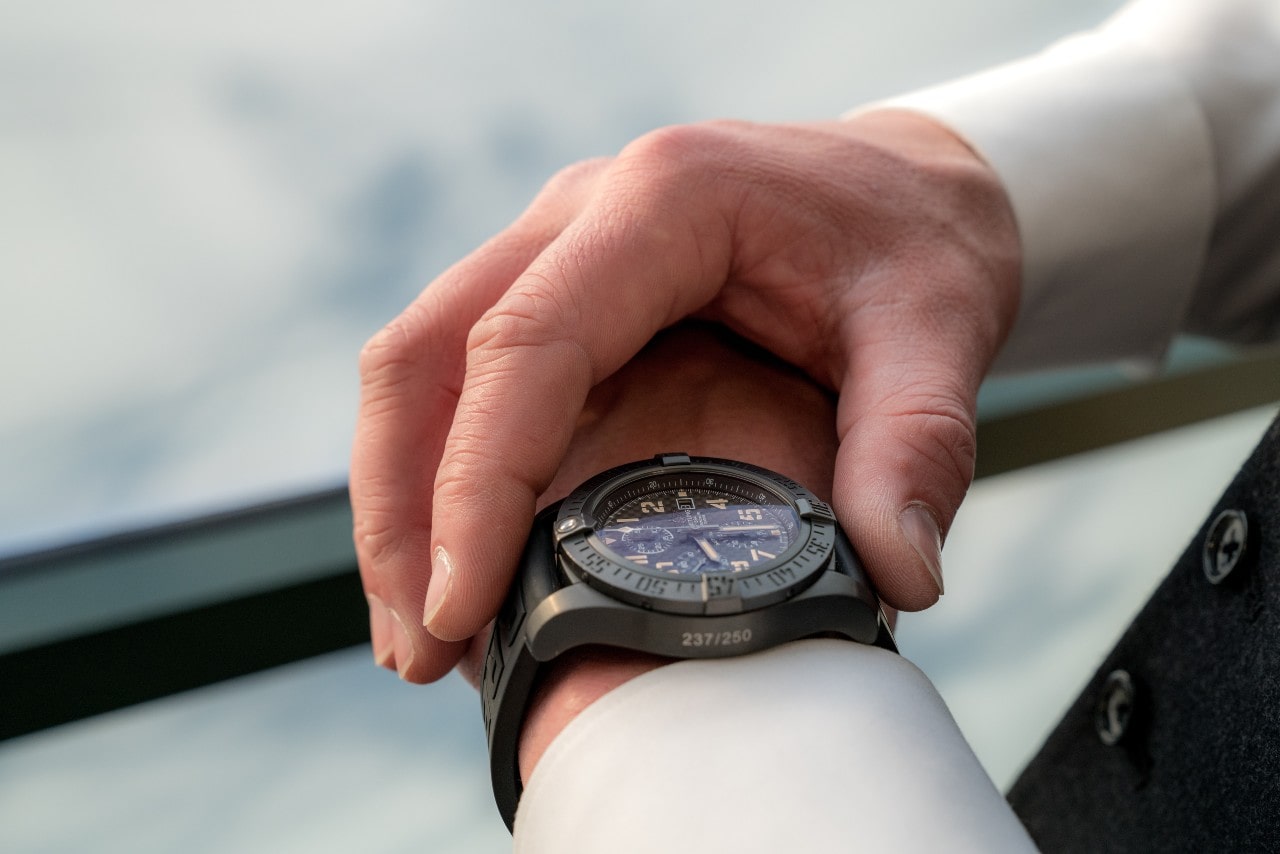 Gunmetal gray watch close-up on a man’s wrist wearing a long-sleeved white shirt