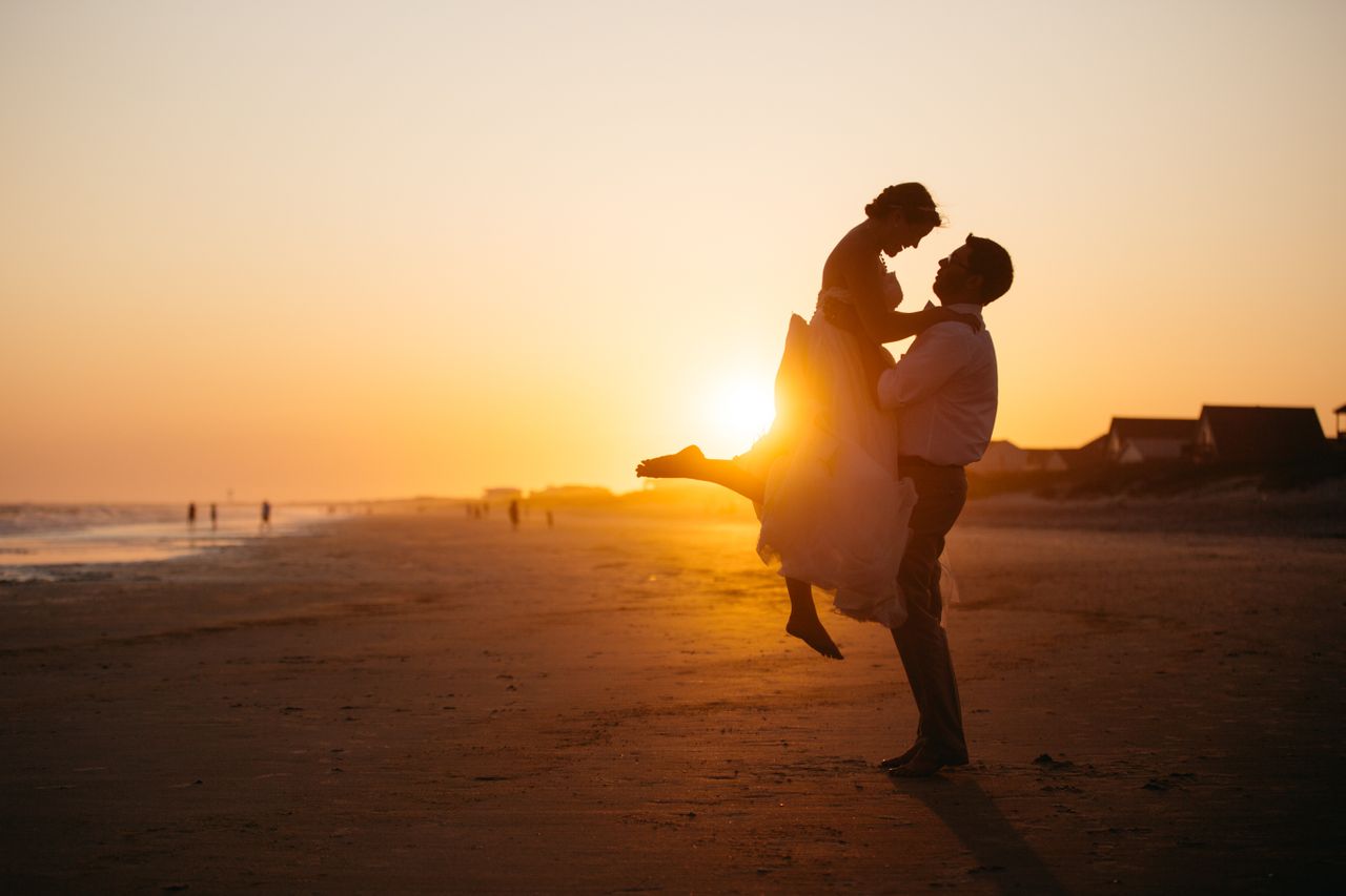 A couple sharing a sunset moment on the beach after their wedding in Miami.