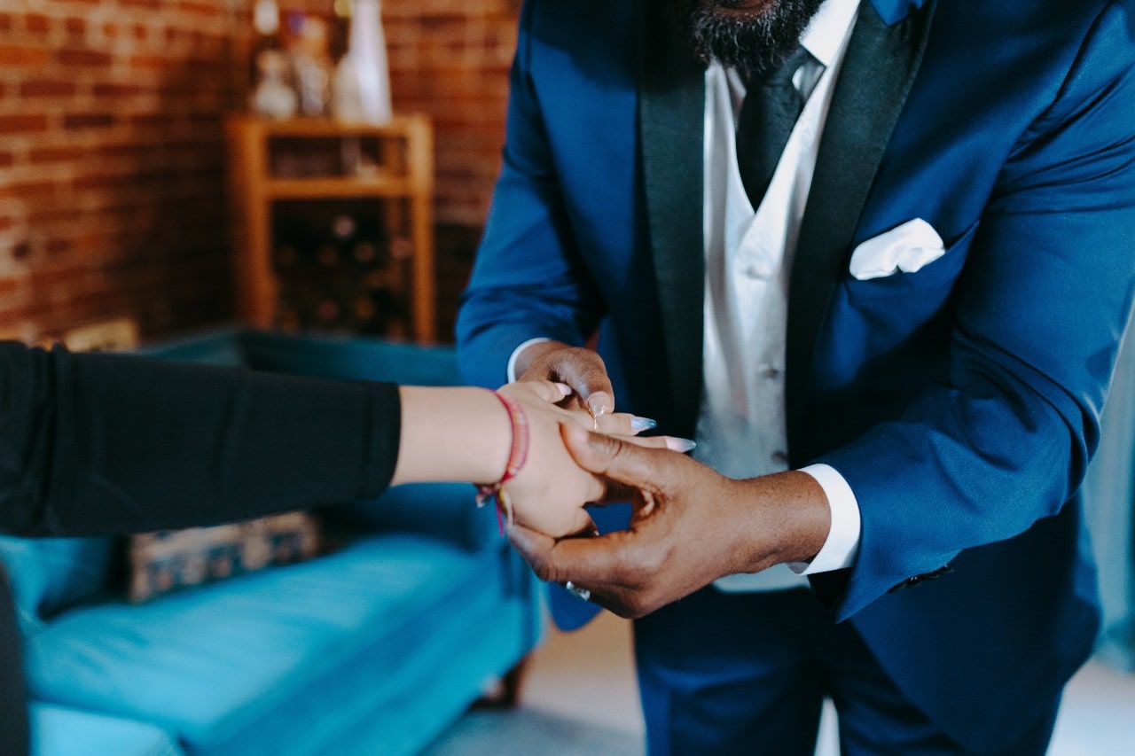 a jeweler helping a lady try on a ring