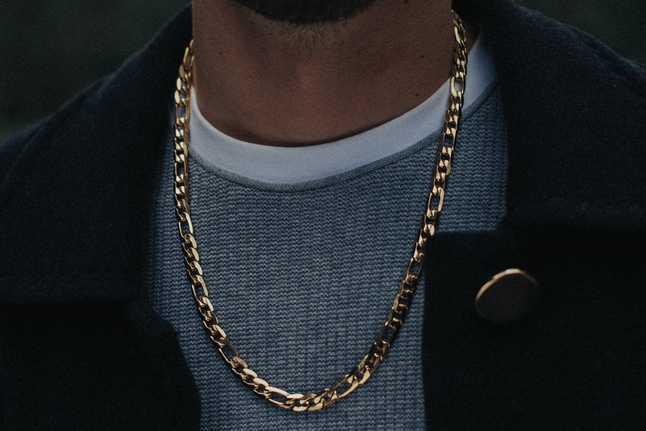 close up image of a man’s neckline adorned with a classic yellow gold chain necklace