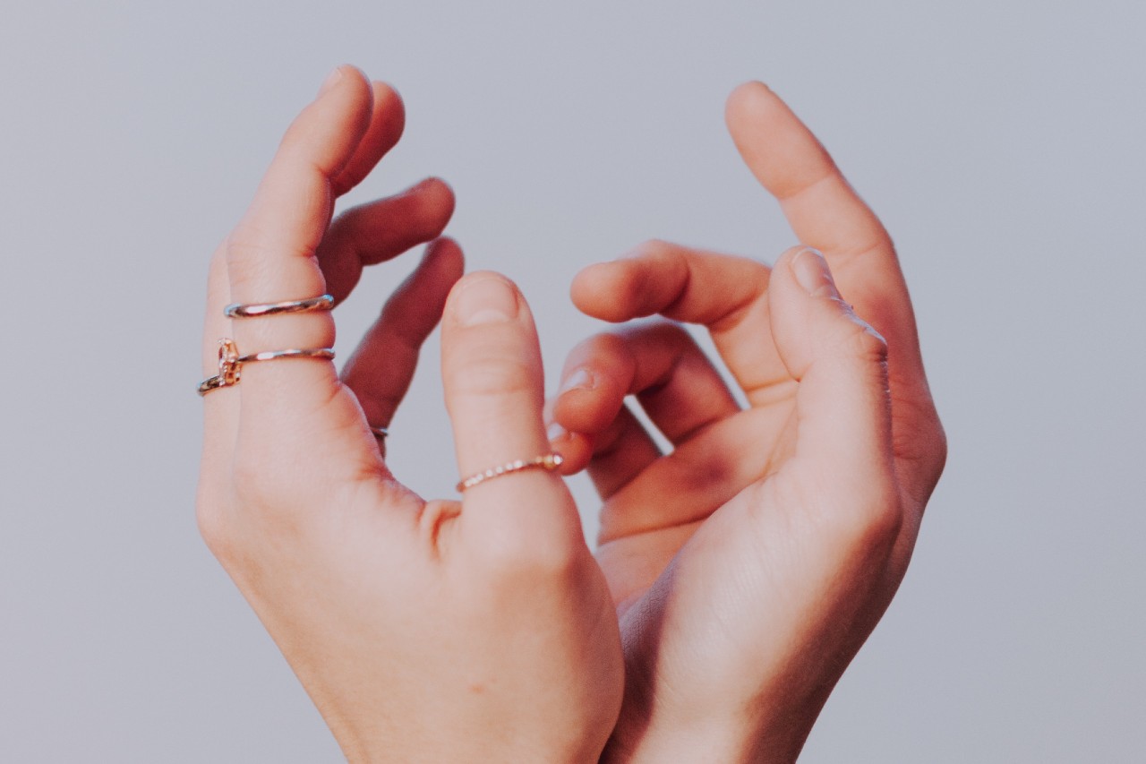 A woman wears a variety of minimalistic rings.