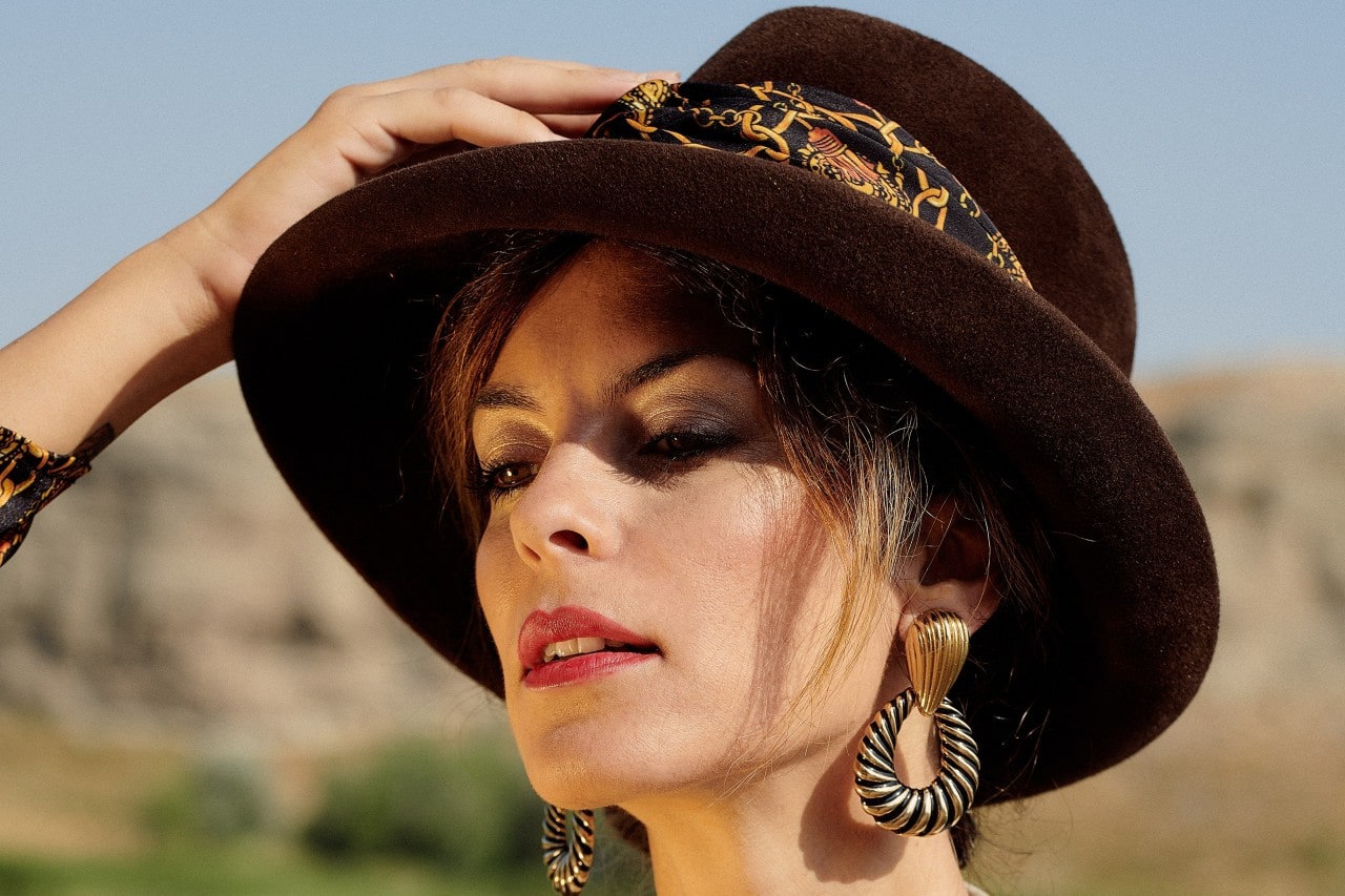 lady wearing large earrings and a hat