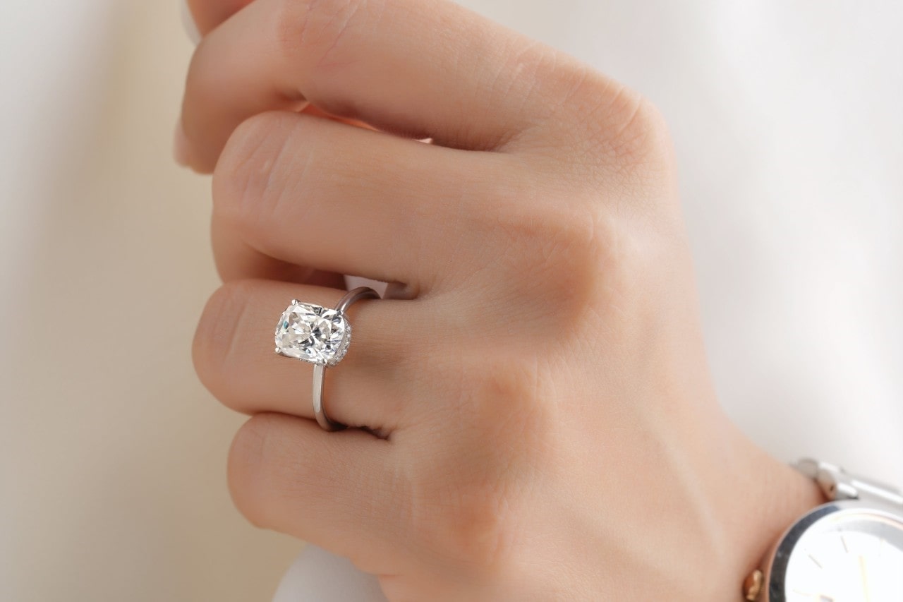a white gold and diamond engagement ring on a lady’s finger