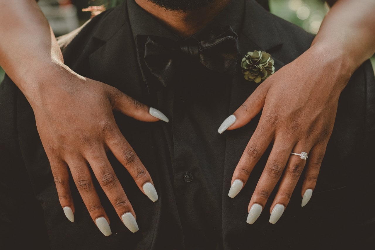 woman holding fiancee with engagement ring