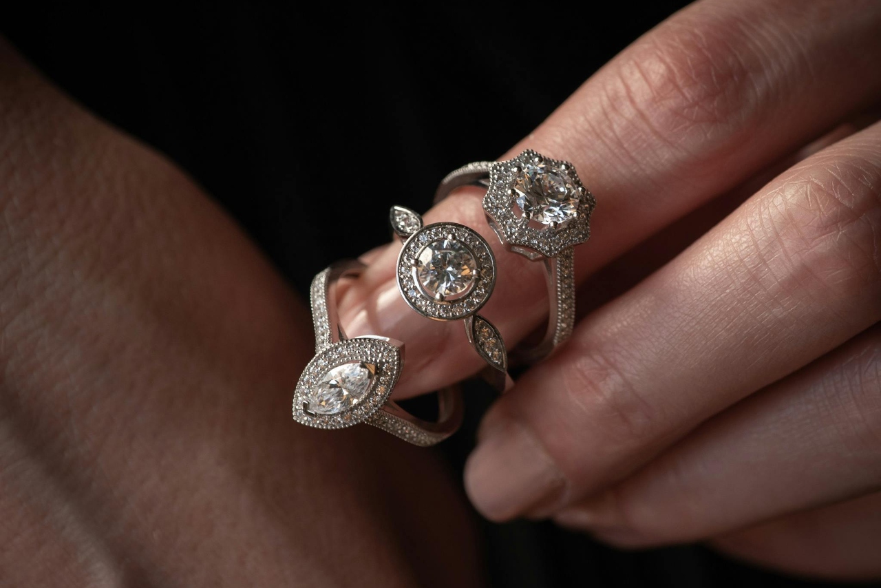 A close-up of three white gold diamond rings on a finger.