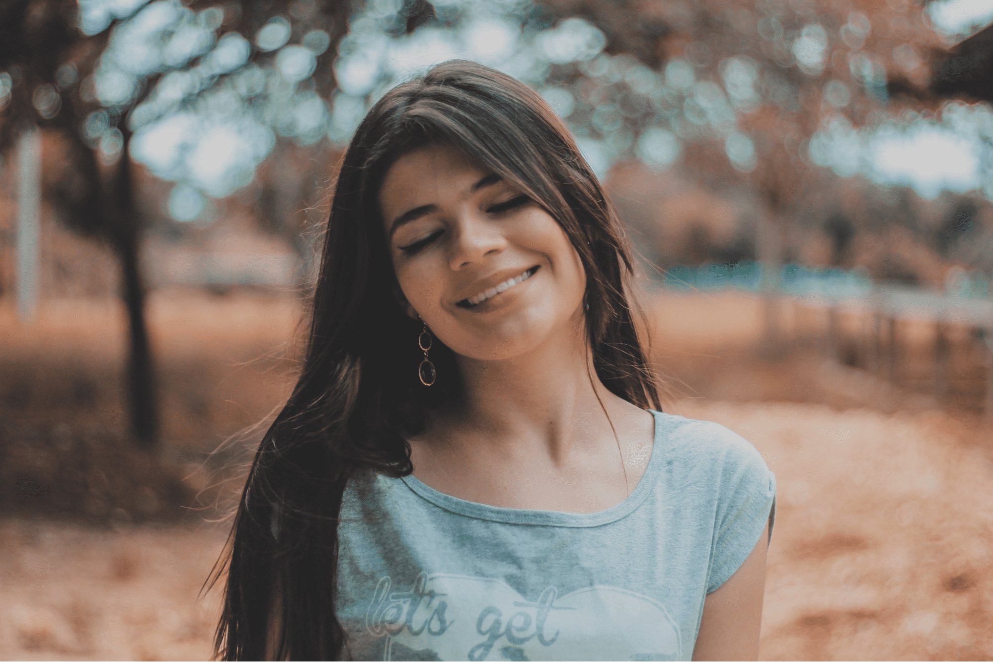 lady standing outside smiling and wearing a pair of fine earrings lady standing outside smiling and wearing a pair of fine earrings
