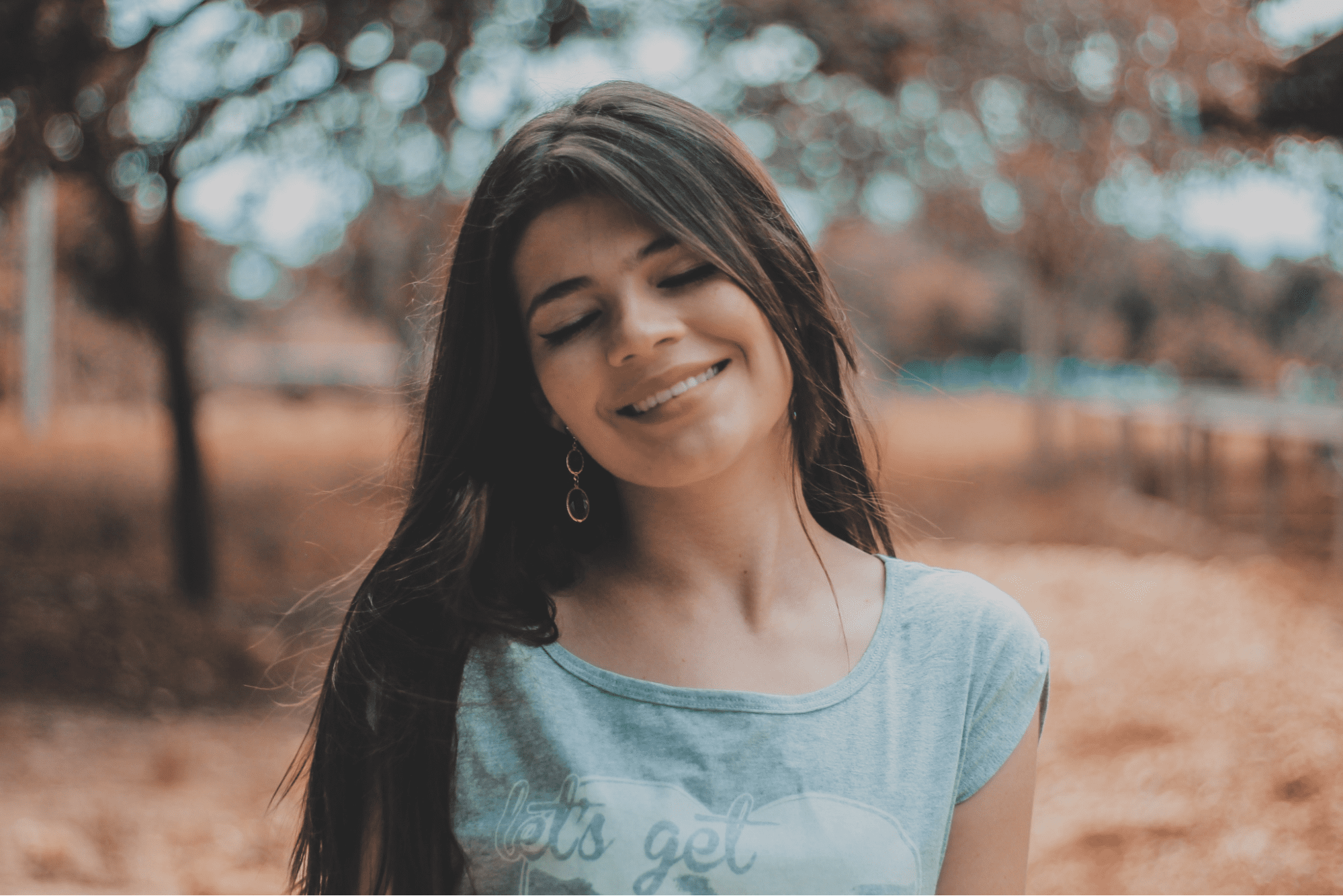 lady standing outside smiling and wearing a pair of fine earrings