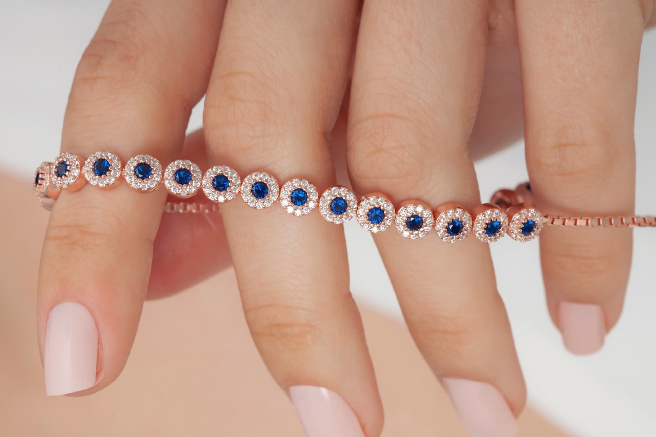 A close-up of a distinctive rose gold diamond bracelet accented with round sapphires.