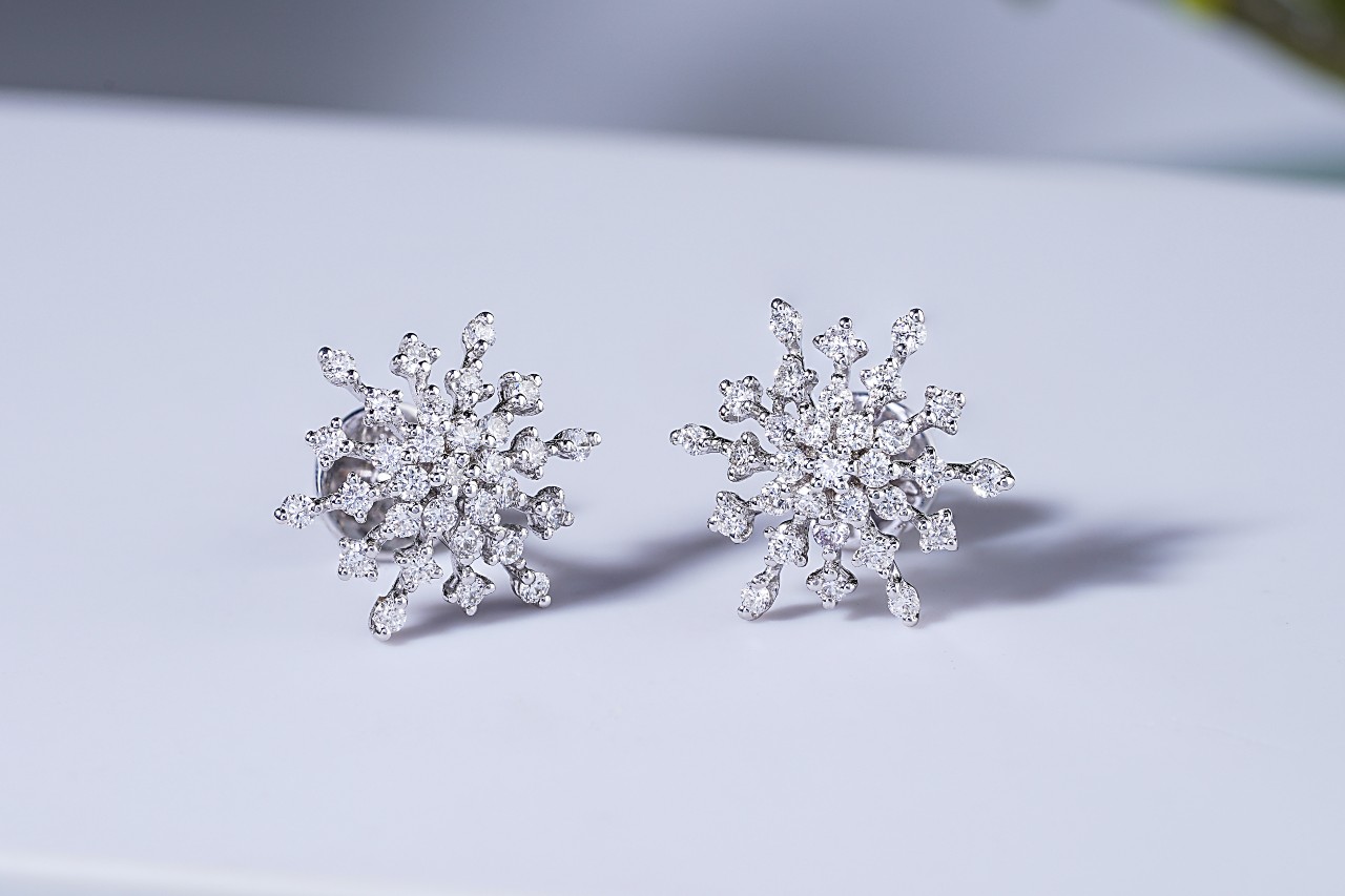 A diamond snowflake-shaped white gold studs on a white background A diamond snowflake-shaped white gold studs on a white background