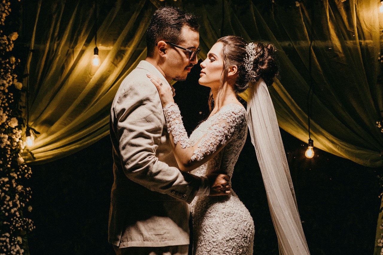 a bride and groom embracing in dim lighting